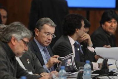 El presidente colombiano, Álvaro Uribe, lee una publicación durante la cumbre de Unasur.