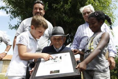 Los biznietos del señor Quico ayudan a su abuelo a localizarse en el cuadro con el que Pinilla homenajea a su supercentenario.