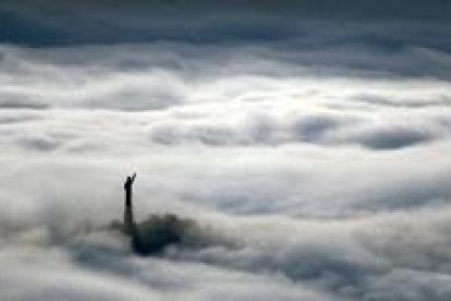 La estatua de Cristo sobresale en la niebla en el valle de Rhone, en Suiza