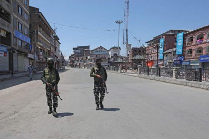 Soldados paramilitares indios patrullan una calle desierta cerca de una barricada en Srinagar. EFE