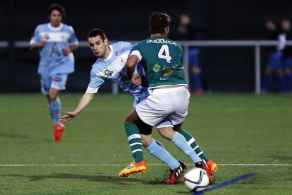 Saúl disputa un balón ante un jugador del Coruxo.