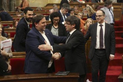 Junqueras y Puigdemont se saludan en el Parlament, en marzo.