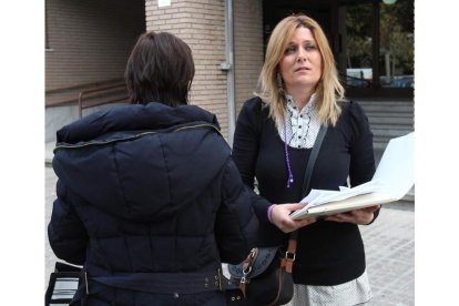 La mujer, de espaldas a las puertas de los juzgados, ayer junto a su abogada Emilia Esteban. DE LA MATA