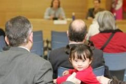 Un padre sujeta a su hija, durante la conferencia en el Club de Prensa