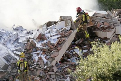 Los bomberos trabajan entre los escombros de la casa unifamiliar derrumbada tras una explosión en Collbató.