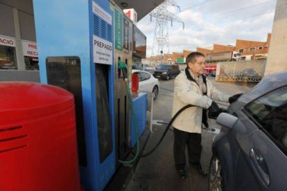 Un hombre reposta su vehículo en una gasolinera.