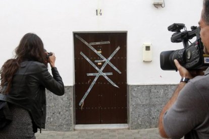 Periodistas tomen fotos ante la vivienda que compartían agresor y víctima en Alcolea del Río, en Sevilla.