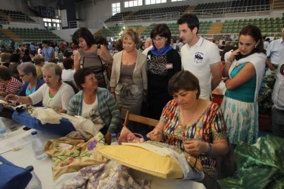 Mari Crespo y Susana Saiz admirando las labores de las artesanas de la muestra.