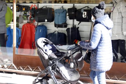 Una mujer pasea con el cochecito de un bebé por el centro de León. MARCIANO PÉREZ