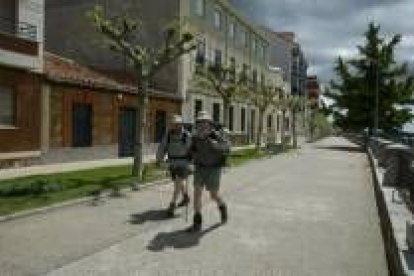 Unos peregrinos caminan por el paseo de la muralla tras llegar a Astorga haciendo la Ruta Jacobea