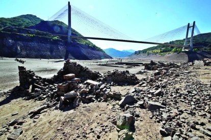 Un pueblo llamado San Pedro de Luna era la capital de la vega, ahora emergen las últimas piedras a escasos metros del puente colgante sobre la autpista.