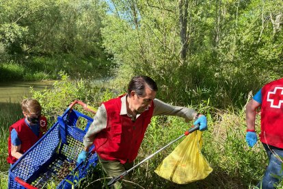 Suárez Quiñones ayuda a retirar un carrito de la compra del río Torío. DL