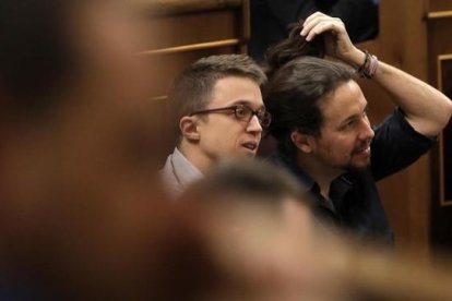 Pablo Iglesias se arregla la coleta mientras escucha el discurso de Sánchez.