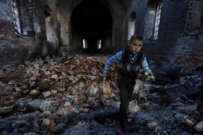 Un niño camina entre las ruinas de una iglesia de Chirnighiv bombardeada por los rusos. OLEG PETRASYUK