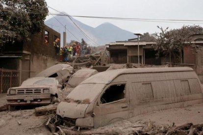 Bomberos y personal de rescate inspecciona los destrozos causados por el volcán de Fuego en Escuintla, Guatemala.