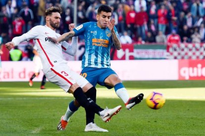 El defensa del Sevilla Sergi Gómez y el delantero argentino del Atlético de Madrid Ángel Correa pugnan por un balón. JOSÉ MANUEL VIDAL