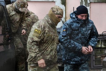 Militar ruso conduce a uno de los marineros detenidos