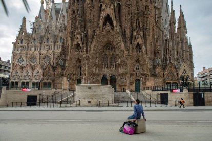 Un hombre sentado ante la Sagrada Familia. ENRIC FONTCUBERTA