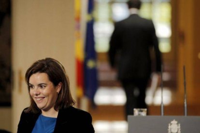 Soraya Sáenz de Santamaría, en primer plano, y Mariano Rajoy, al fondo de espaldas, durante el último Consejo de Ministros.