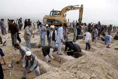 Decenas de personas han acudido a un cementerio de Kabul a cavar tumbas para las víctimas del atentado.