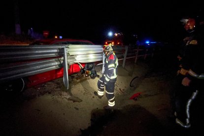 Intervención de los bomberos para liberar el coche empotrado en la LE-30. BOMBEROS DE LEÓN