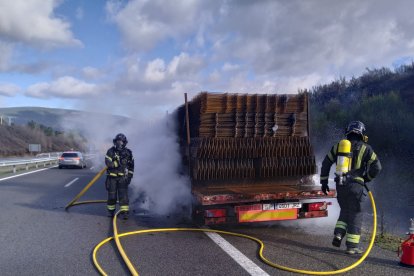 El camión ardiendo en la zona de su eje trasero en la autovía A-6. DL