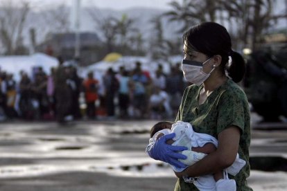 Una enfermera lleva en brazos a un bebé de siete días para evacuarlo.