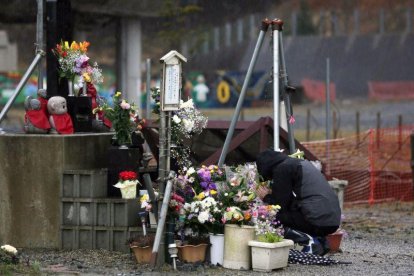 Un hombre ora en un altar de la víctimas del terremoto y tsunami en Fukusima, Japón.