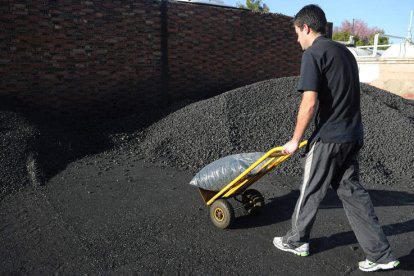 Un trabajador traslada un saco con carbón doméstico para una vivienda. JAVIER QUINTANA