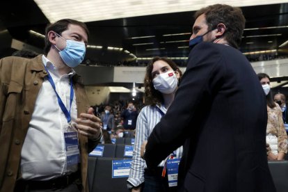 El presidente de Castilla y León, Alfonso Fernández Mañueco (i), conversa con Pablo Casado (d) ante la presidenta de la Comunidad de Madrid, Isabel Díaz Ayuso, durante la segunda jornada del XX Congreso Nacional del PP que se celebra en Sevilla.  JULIO MUÑOZ