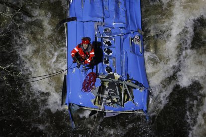 Los bomberos trabajan en el rescate de víctimas del autobús que se precipitó al río Lérez, tras caer de un puente, esta noche en Cerdedo-Cotobade. LAVANDEIRA JR