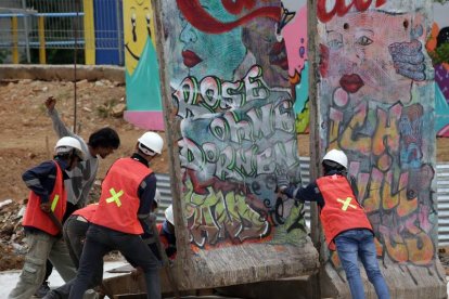 Trabajadores indonesios colocan cuatro partes del muro de Berlín. BAGUS INDAHONO