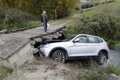 Un vecino contempla la escena sobre el puente del canal de La Martina. L. DE LA MATA