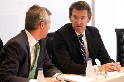 Alberto Núñez Feijóo (de frente), conversa con el consejero de Presidencia, durante el Consejo.