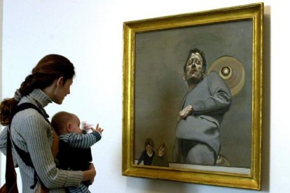 Una mujer observa la obra ‘Autorretrato con dos niños’, de Lucien Freud