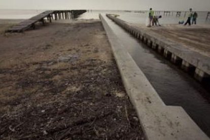 Trabajadores limpian la playa de petróleo y alquitrán, en Waveland, Mississippi.