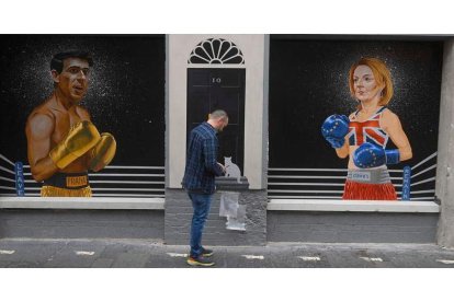 Ciaran Gallagher da los toques finales a su mural en Belfast con Rishi Sunak y Liz Truss separados por el 10 de Downing Street. MARK MARLOW