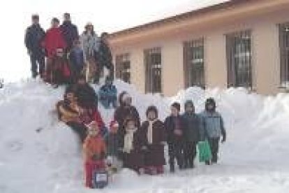 Los niños disfrutan con juegos de la copiosa nieve en el patio del colegio de Riaño