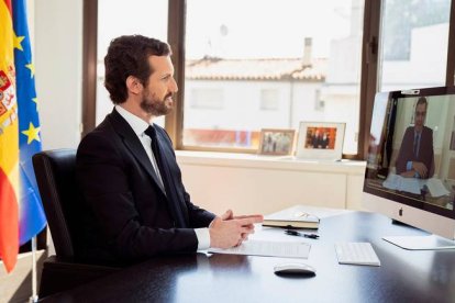 El líder del Partido Popular, Pablo Casado (izq), mantiene una videoconferencia con el presidente del Gobierno español, Pedro Sánchez. DAVID MUDARRA