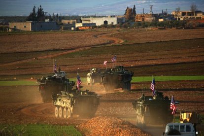 Un convoy de tanques con bande ra de EEUU circulan a las afueras de la ciudad de Manbij, al norte de Siria.