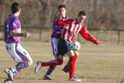 Óscar, en segundo término, trata de impedir el avance de un jugador local