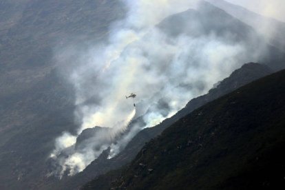 Un helicóptero se aproximaba ayer a la zona de Peñalba de Santiago donde la orografía hacía imposible el trabajo de las cuadrillas de tierra. ANA F. BARREDO