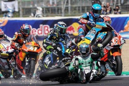 Àlex Márquez (Kalex), a la derecha, con casco azul, salta, vuela, por encima de la moto y el cuerpo del australiano Remy Gardner, sentado ya en la pista tras su caída, en la salida de hoy de Moto2, en Jerez.