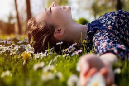 Una mujer, tendida en la hierba en primavera.