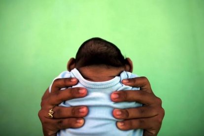 Jackeline sostiene a su hijo de 4 meses de edad y nacido con (Zika) microcefália frente a su casa en Olinda, cerca de Recife, Brasil.