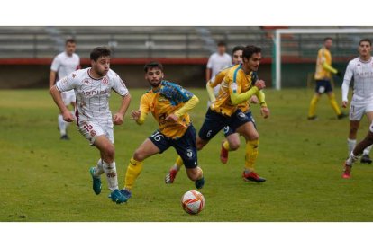 El leonés Abel se lleva un balón a pesar de la oposición de un jugador abulense. FERNANDO OTERO