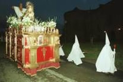 Cofrades pasean a la Virgen ante el castillo de Villafranca, en una Semana Santa