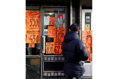 Un hombre pasa ante una tienda de comestibles en León. FERNANDO OTERO