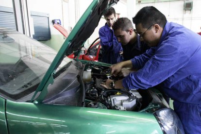 Alumnos de FP hacen prácticas en un automóvil .