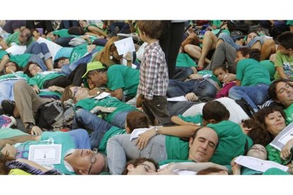 Un niño sobresale entre las numerosas personas ataviadas con camisetas verdes que han escenificado hoy en el centro de Madrid la "muerte" de la Enseñanza pública.